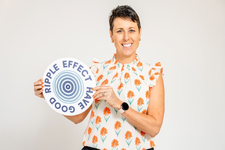 Kelly, IAPRA President, holding a sign that says Have Good Ripple Effect